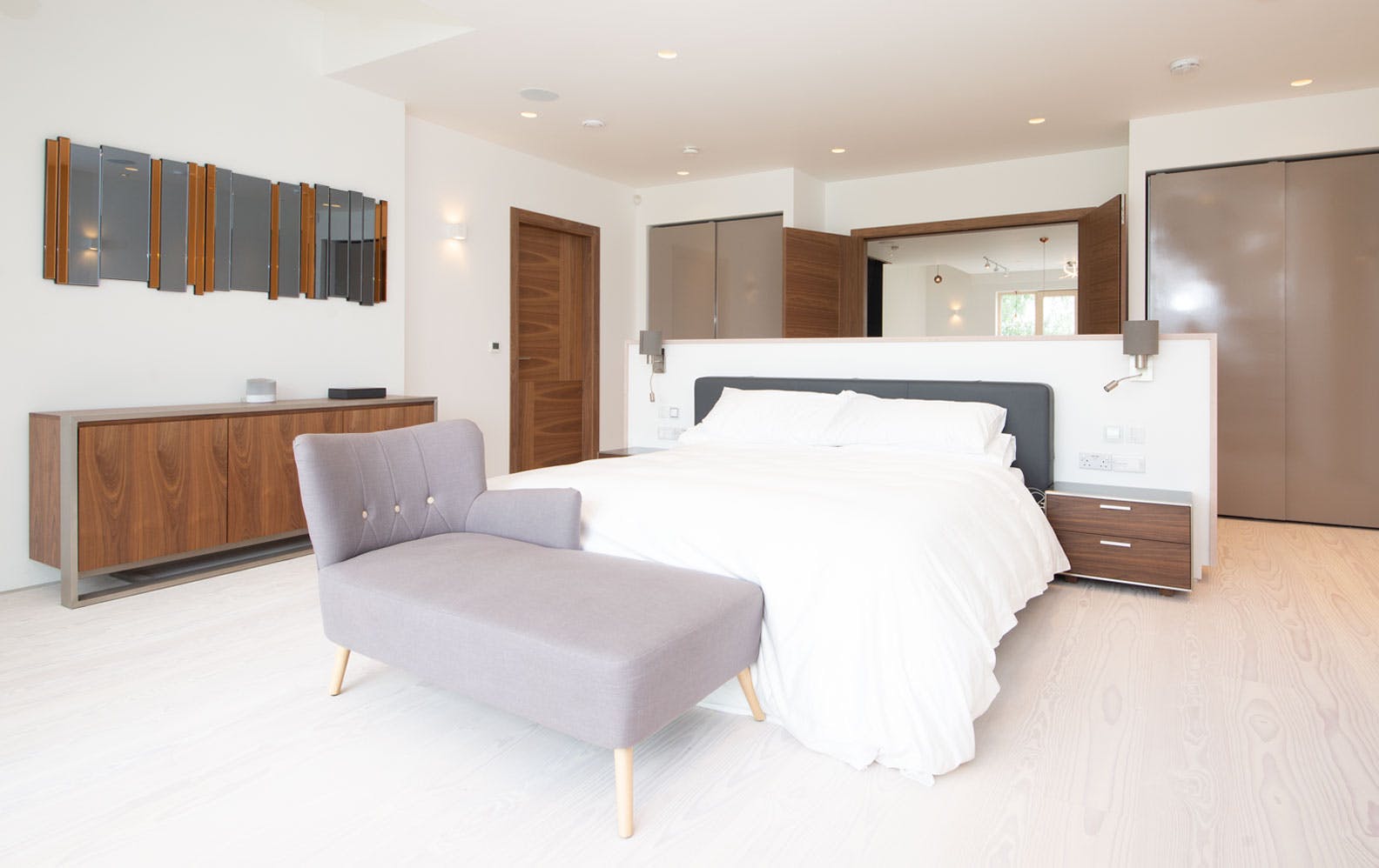 A generous modern master bedroom featuring Deuren door sets- Vario 4 style, in a walnut veneer finish.