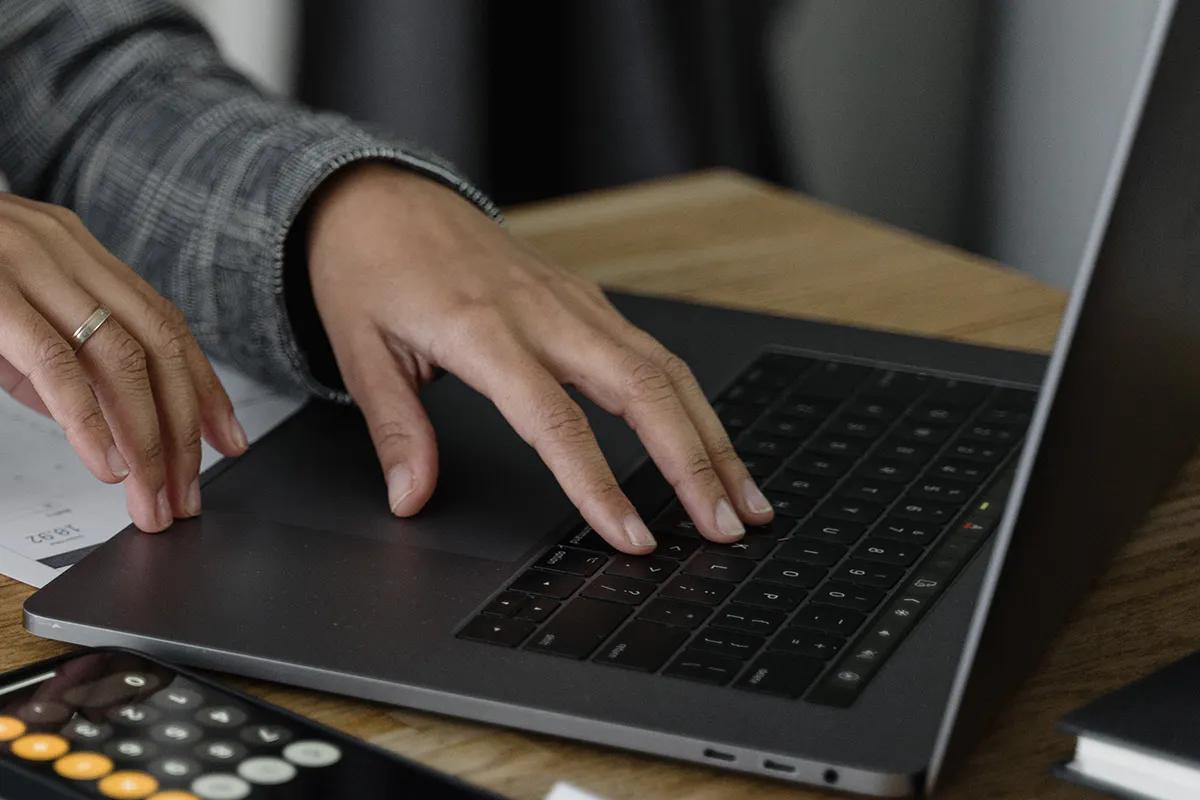 close-up of someone typing at a laptop