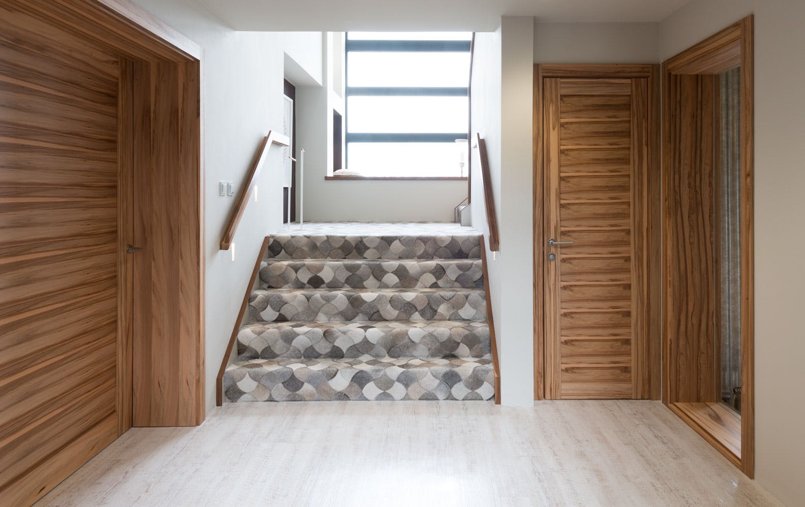 A modern hallway featuring extra wide and narrow door sets, with extra deep frames demonstrates Deuren's made-to-measure door set capabilities.