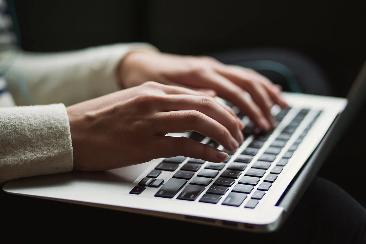 hands typing on a laptop