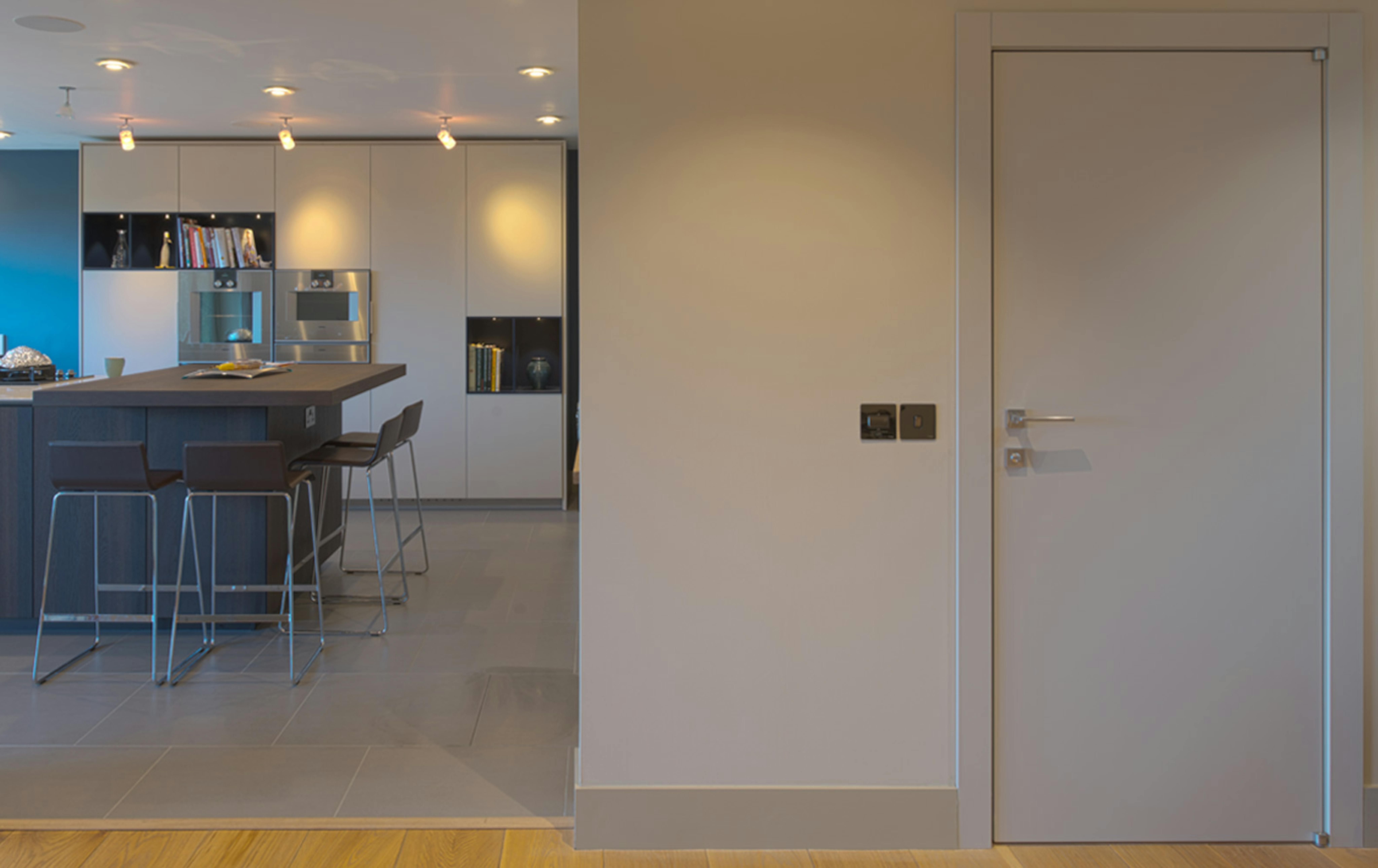View of modern kitchen and a modern Deuren door set- Trem painted (smooth, slab door) in White.