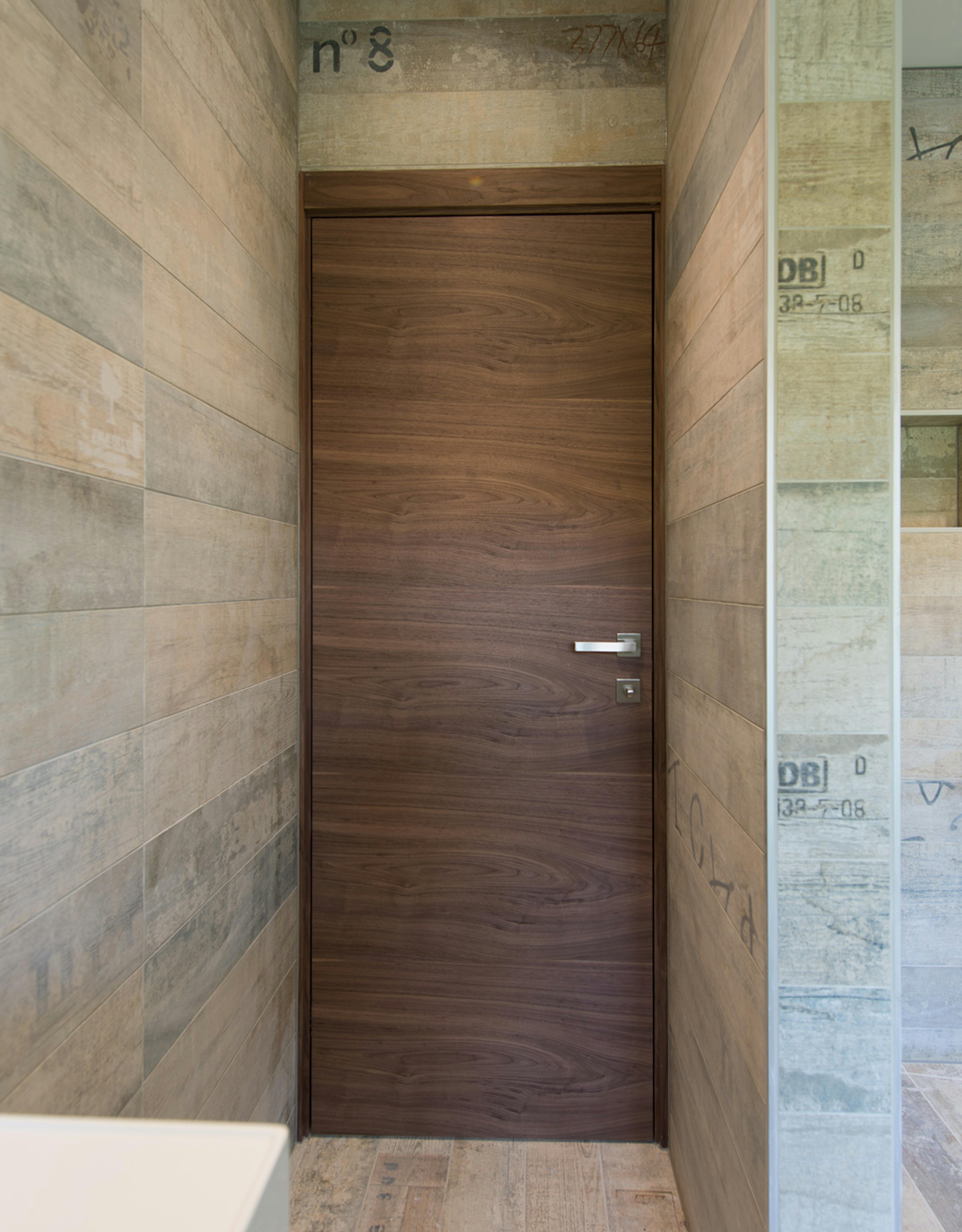 Bathroom with Deuren's contemporary internal door set -  Trem H style in Walnut finish with chrome lever handle.