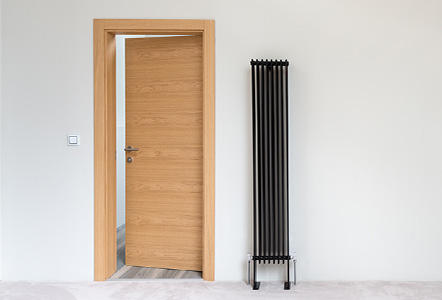 A light wood single leaf hinged door.