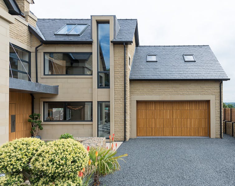 External photo of a house with a matching Deuren Tavole S front and garage door 