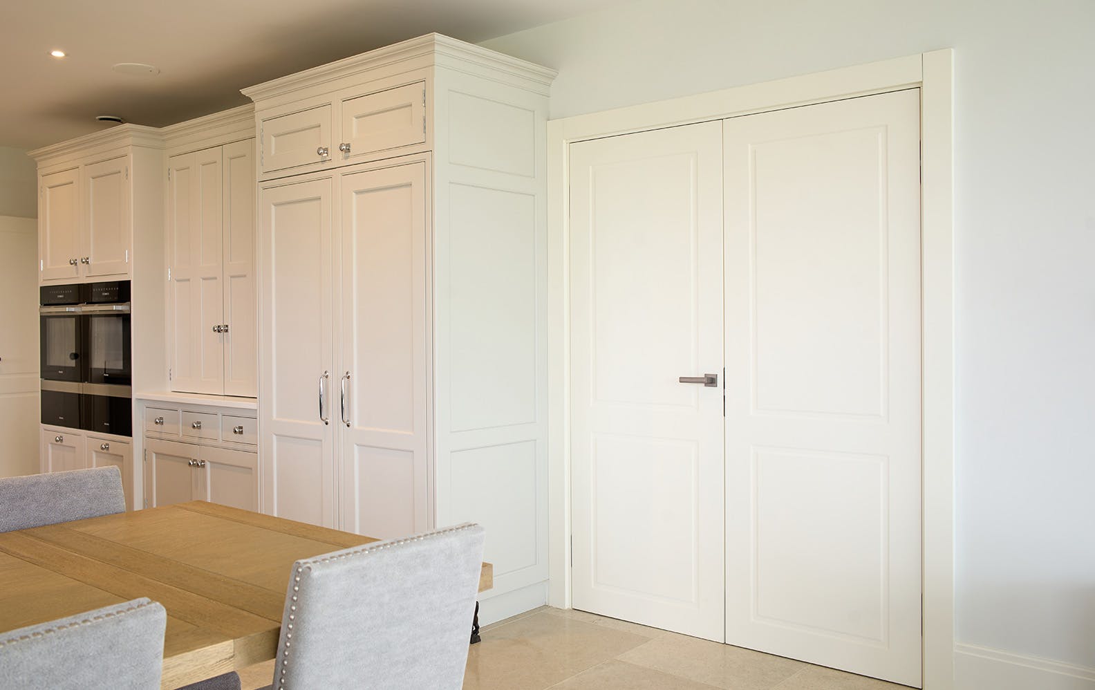 A modern country style kitchen featuring a double leaf Deuren door set - Victorian style  with two routed rectangluar shaped details in a white painted finish.