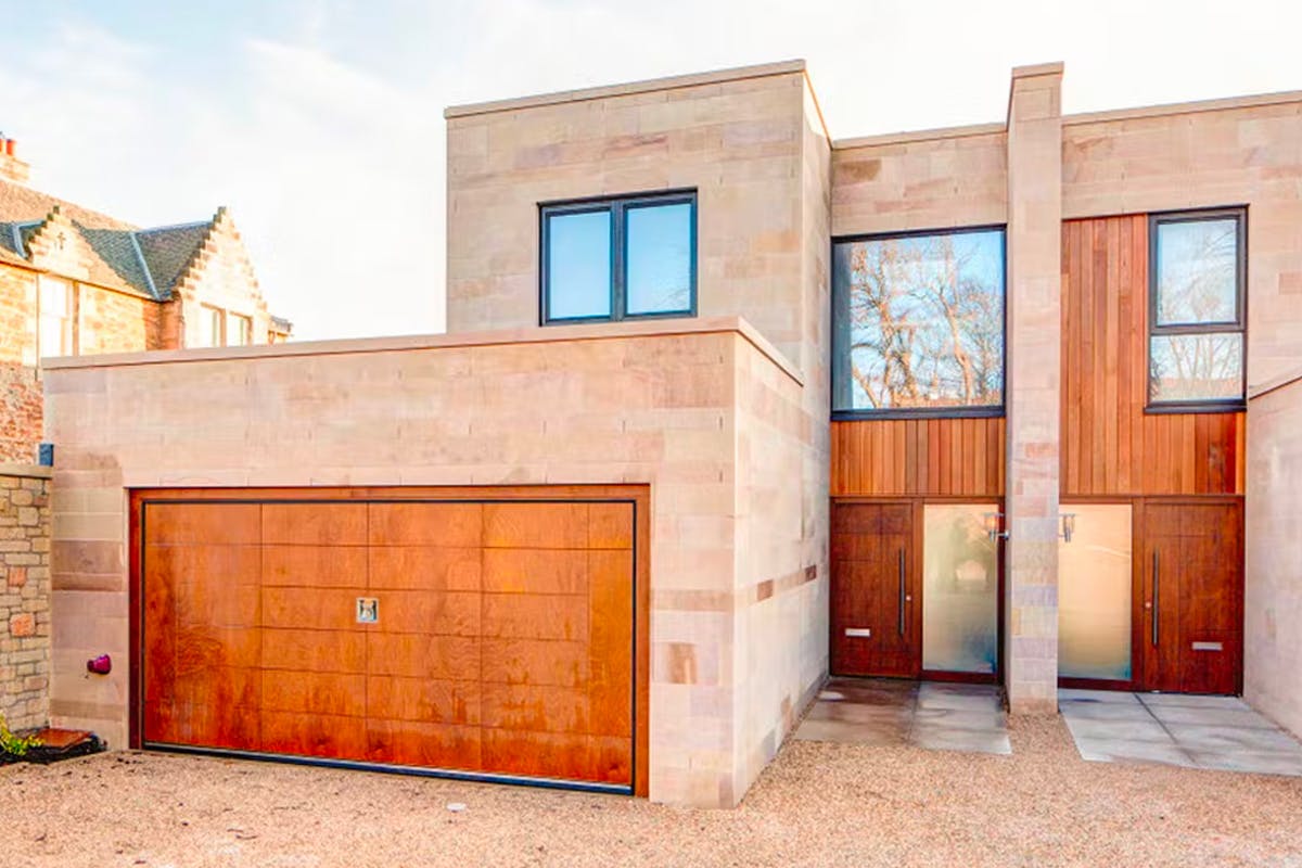 Modern home with Deuren's made-to-measure garage door in red oak.
