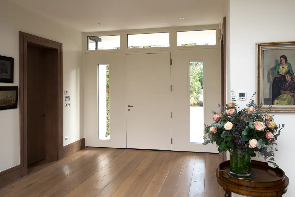Internal view of a Deuren modern entrance door - Trem in a painted finish, with glazed panels to both sides.