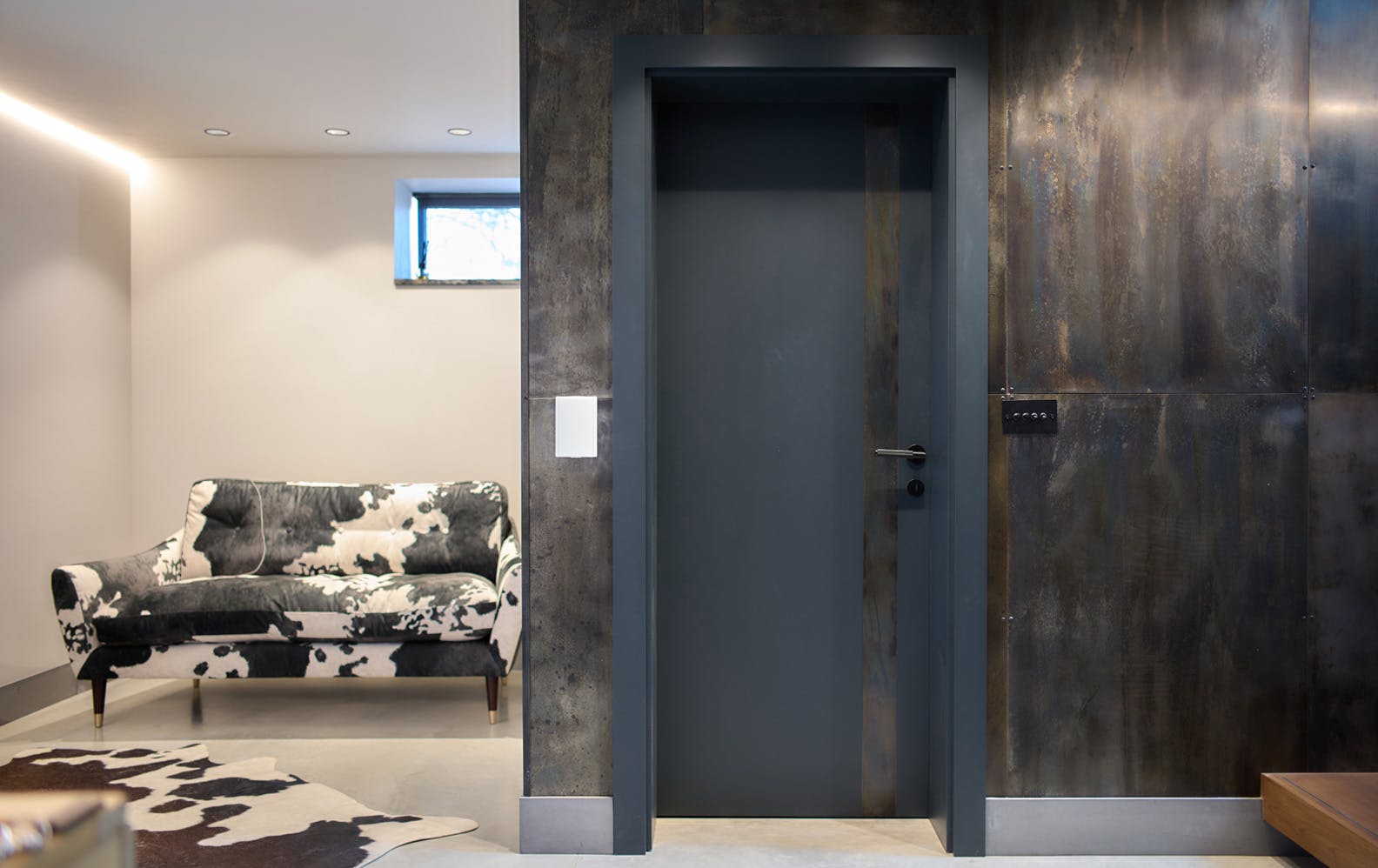 Deuren's bespoke Trem H pocket door in anthrite grey paint finish, featuring a vertical metal strip to the right. 