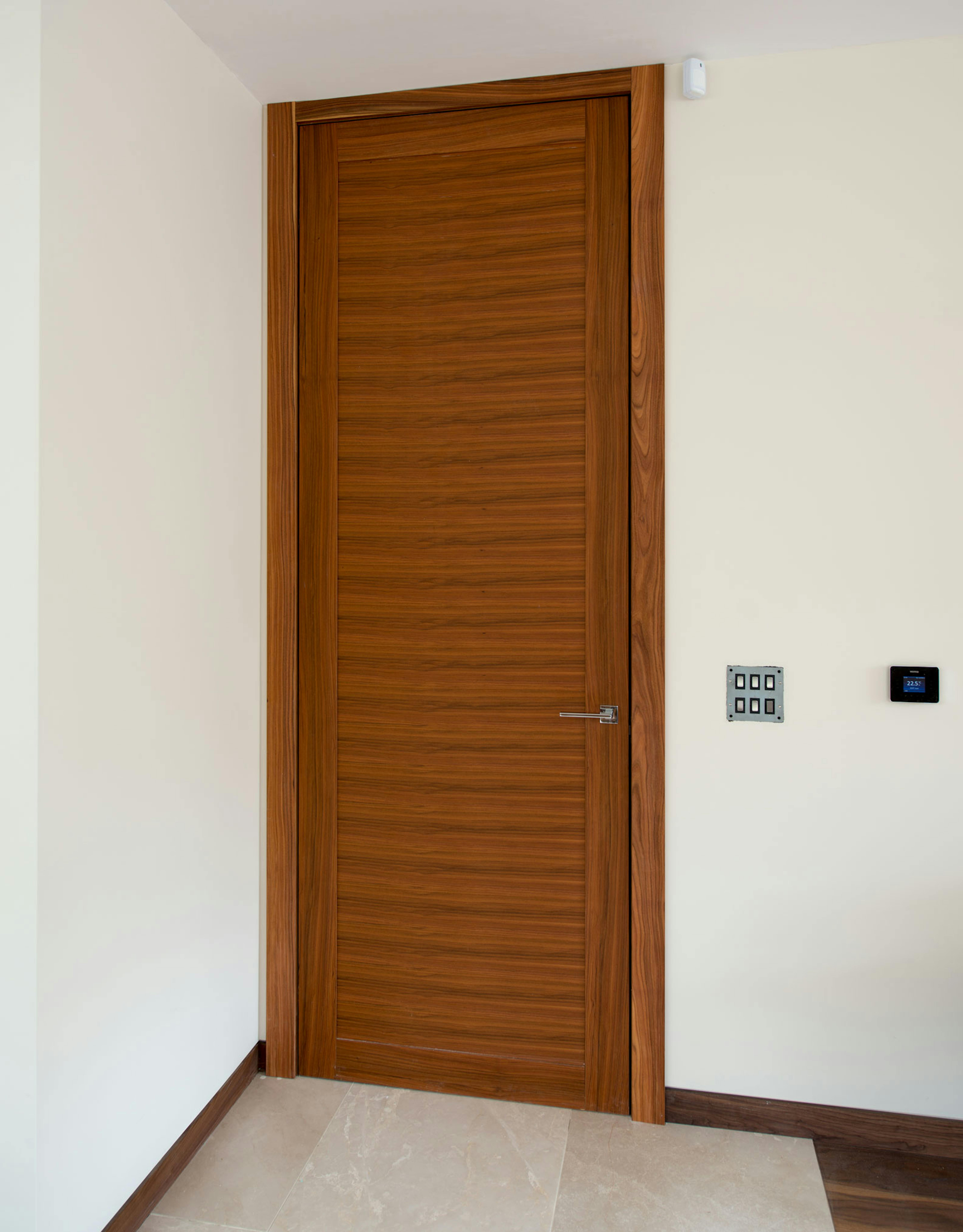 Contemporary pre-hung door set in Trem H, Rosewood finish, by Deuren.