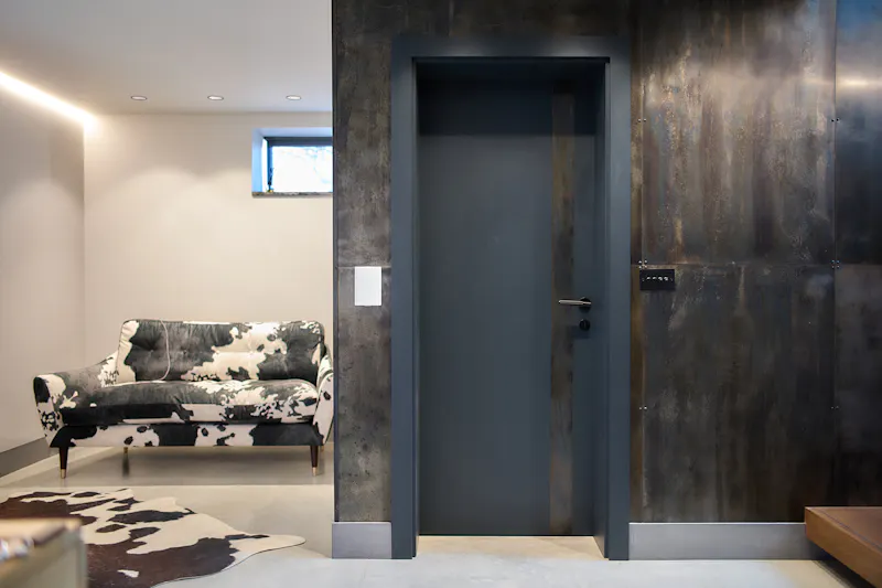 Deuren's bespoke Trem H pocket door in anthrite grey paint finish, featuring a vertical metal strip to the right.