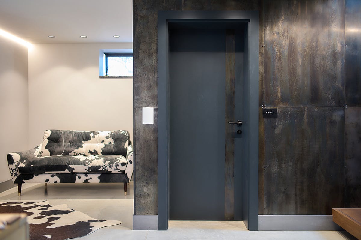 Deuren's bespoke Trem H pocket door in anthrite grey paint finish, featuring a vertical metal strip to the right.