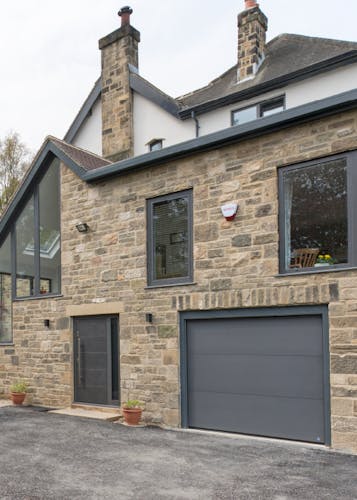 modern house exterior with matching black front and garage doors