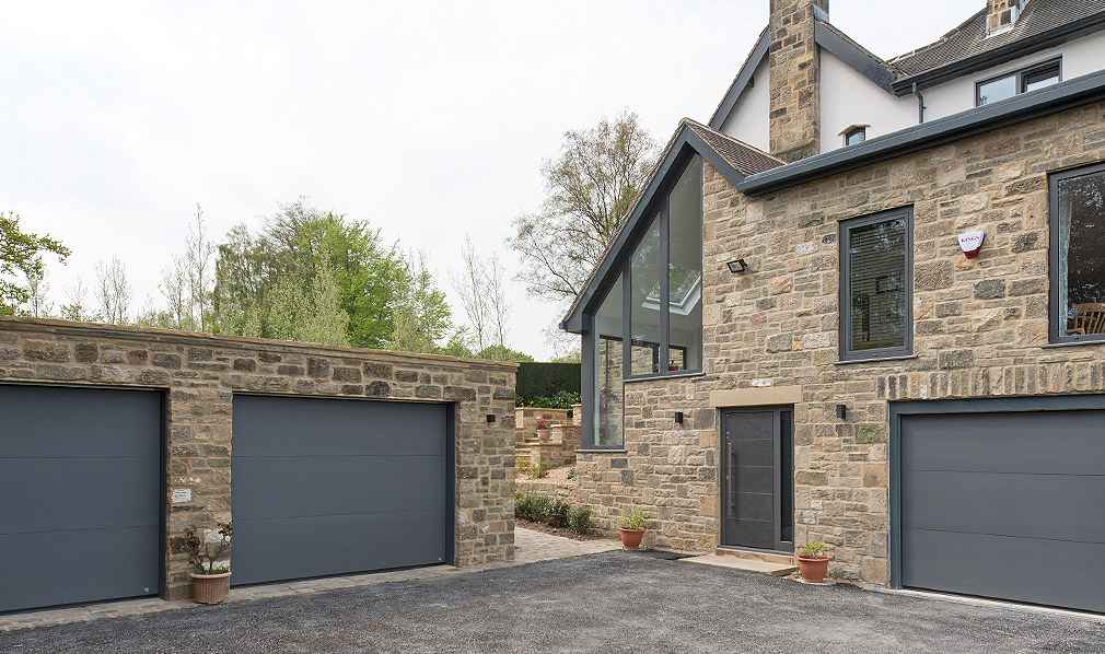 A modern residential building with a brick exterior and 3 garage doors