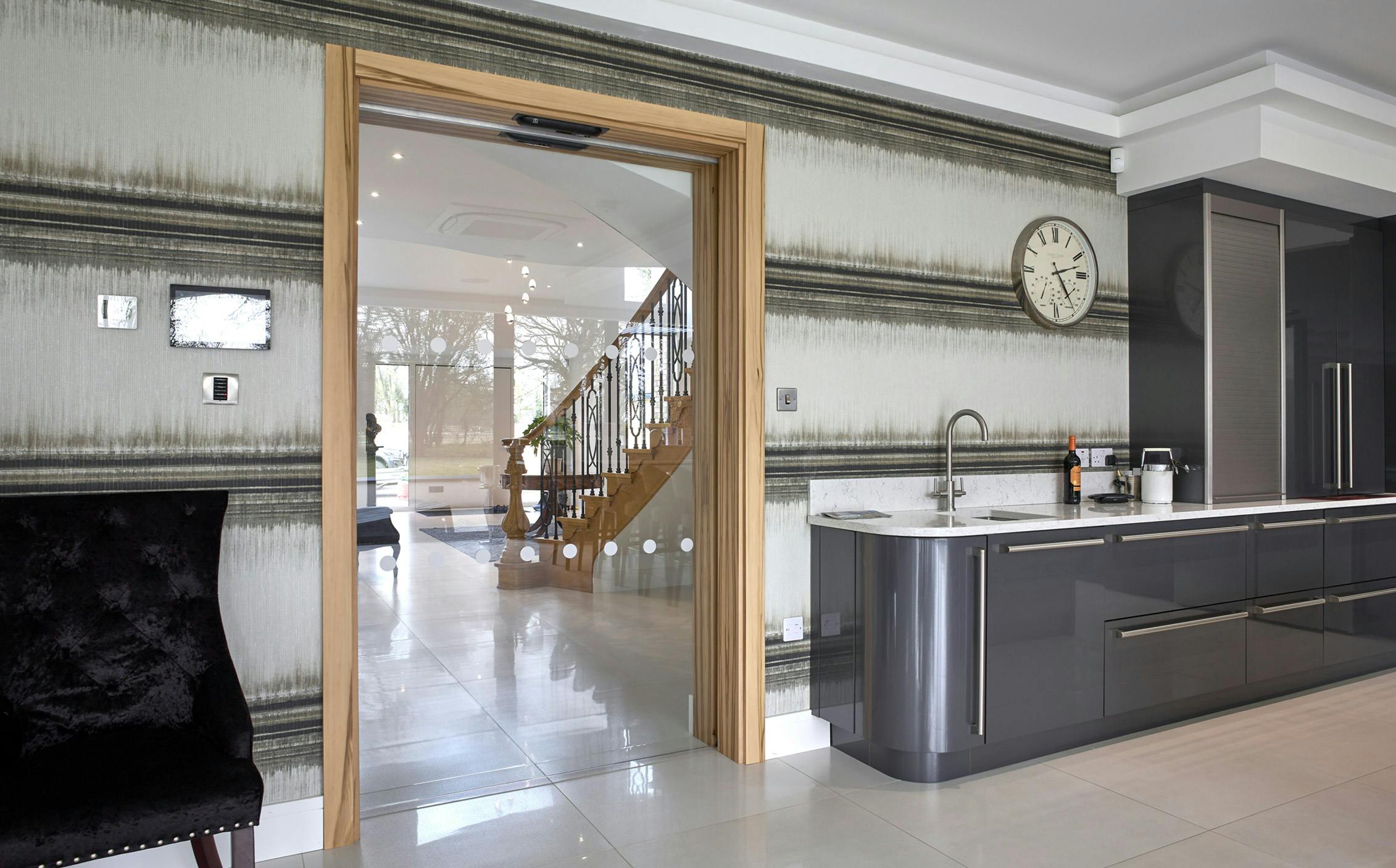 Modern kitchen with a customised Deuren door set -  Vetro is an all glass door, here it has configured as an automatic pocket door.