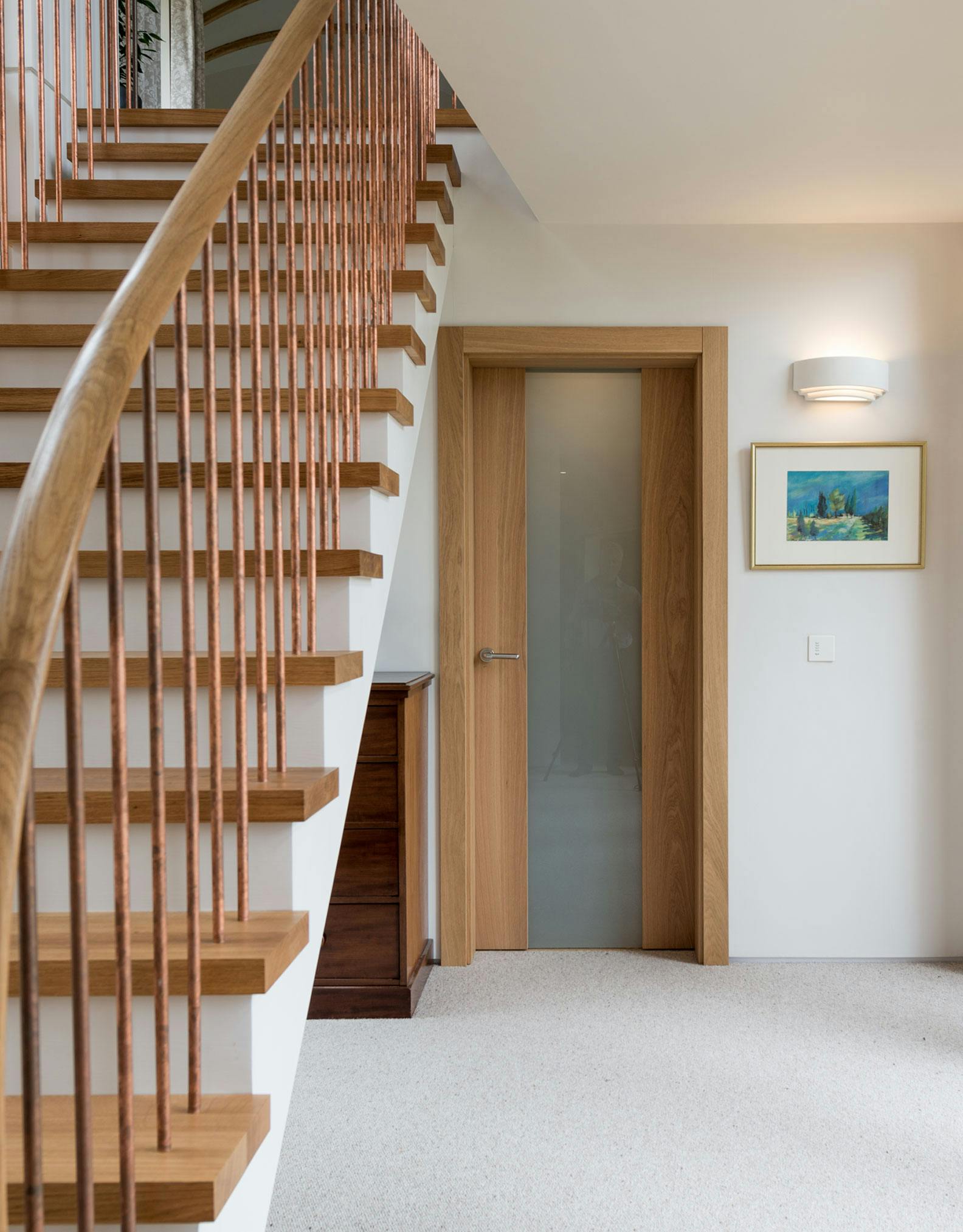 Contemporary hallway featuring a pre-hung Deuren door set. Style is Trem glazed, a full height pane of satin glass held between two full height strips of natural oak veneered timber. 