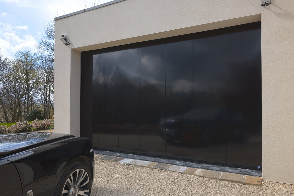 A slick Deuren side-sectional garage door - Olivio in a black paint finish.