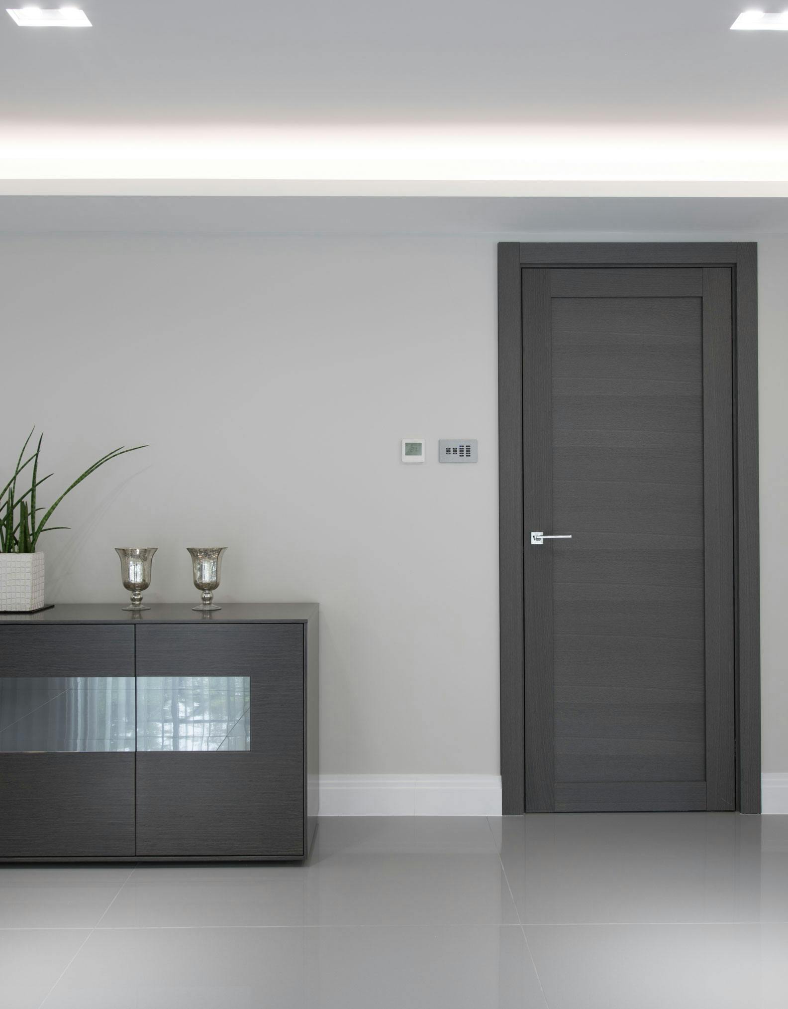 Sophisticated living area with a contemporary pre-hung door set in Gio,  grey oak finish, by Deuren.