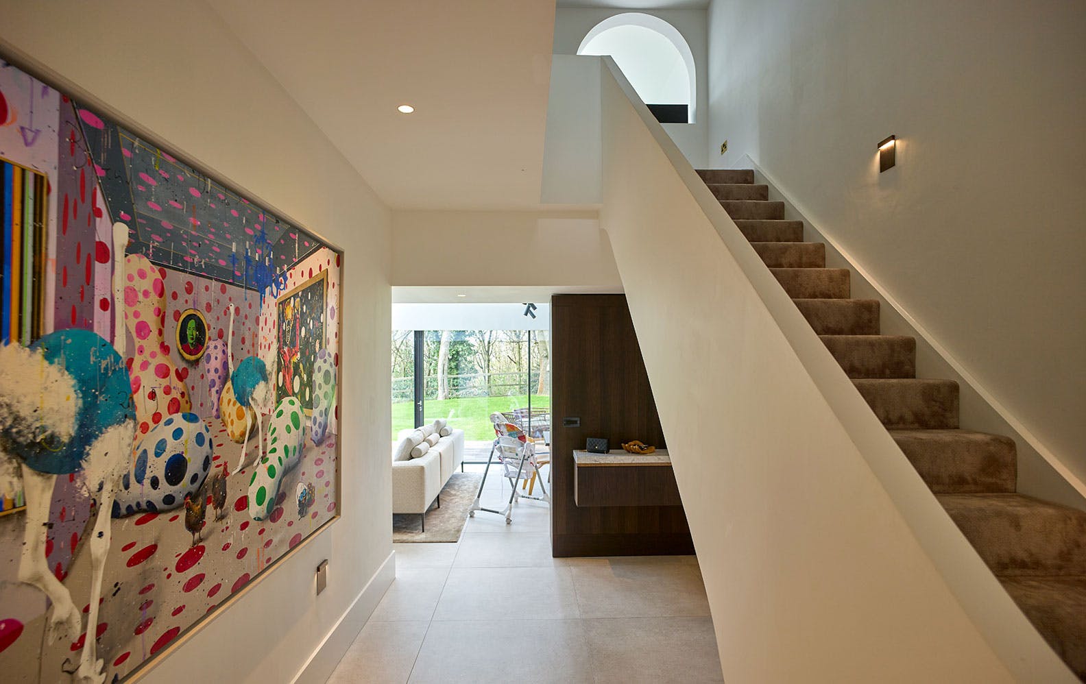 luxurious hallway and staircase featuring an extra large, colourful and surreal painting.