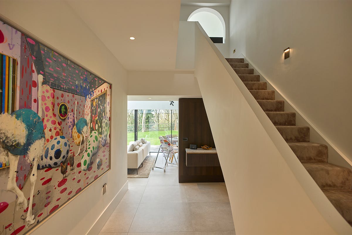 luxurious hallway and staircase featuring an extra large, colourful and surreal painting.