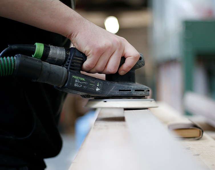 Close up of a hand sanding a door