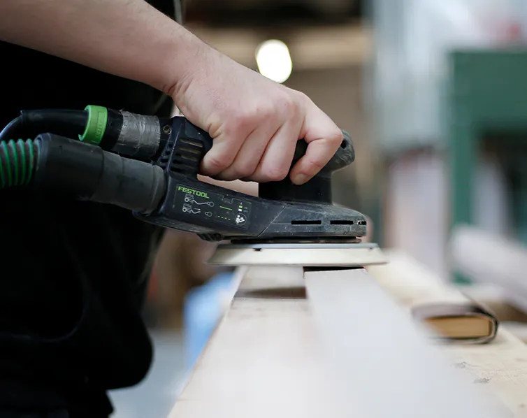 Close up of a hand sanding a door