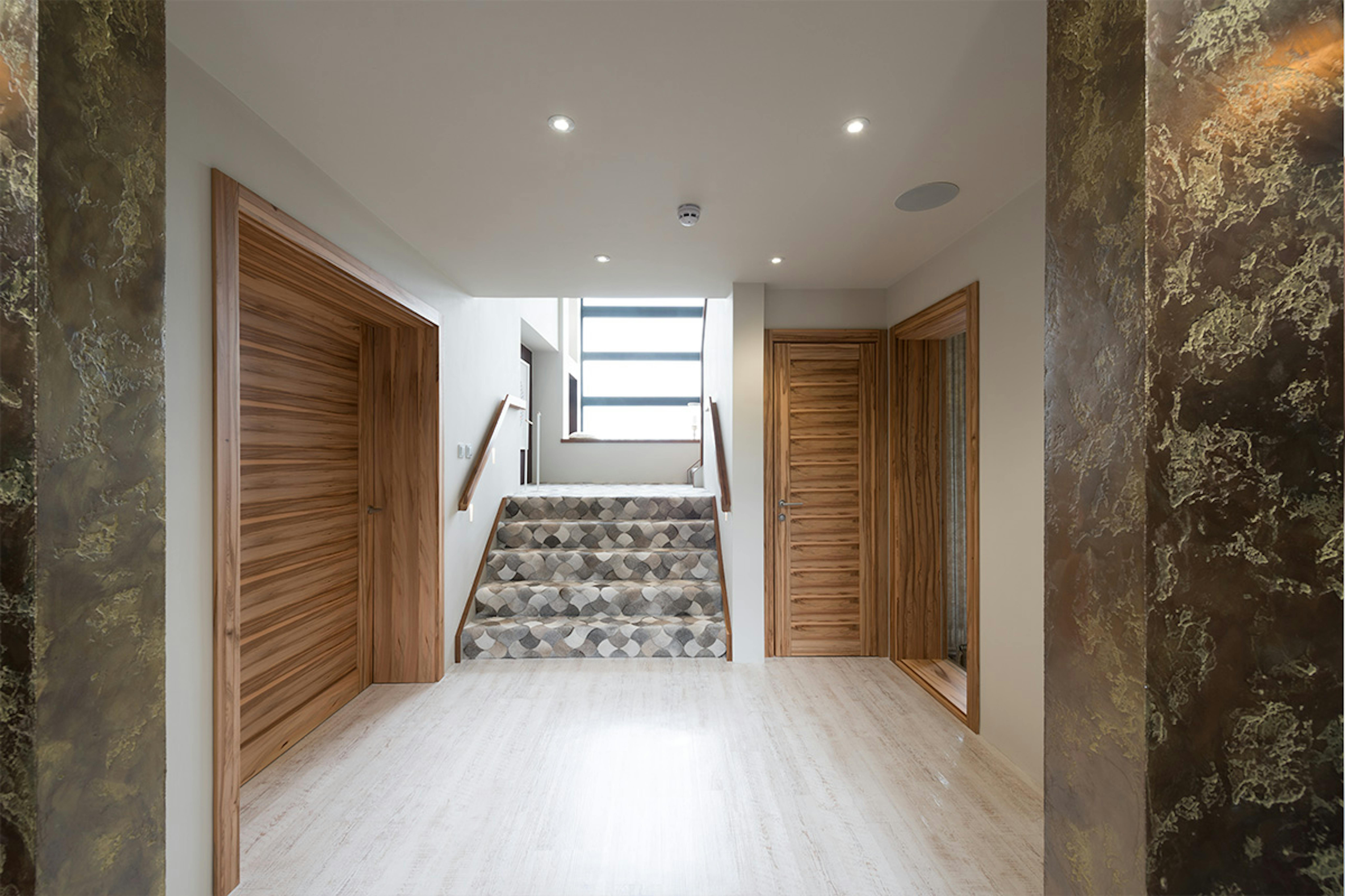 Self-build home  hallway and staircase featuring two modern pre-hung door sets by Deuren in Gio Satin Walnut
