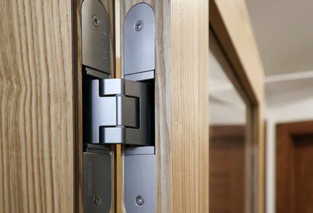 A close up of a hinge set into a wooden interior bi-fold door.
