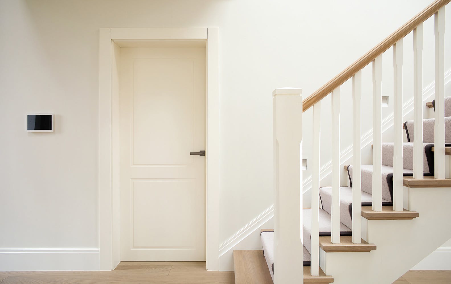 A hallway featuring a single hinged Deuren door set - Victorian style with two routed rectangluar shaped details in a white painted finish.