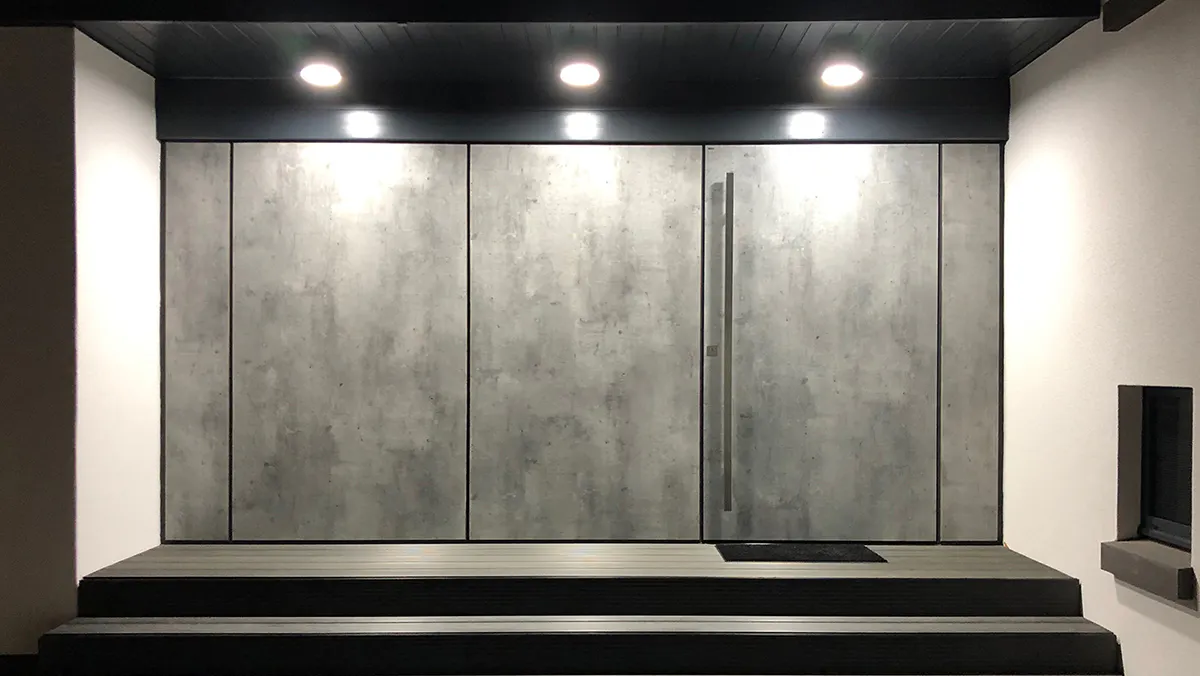 Contemporary home exterior - Full concrete look front door and side cladding in Deuren's LMF finish for a continuous flush appearance.
