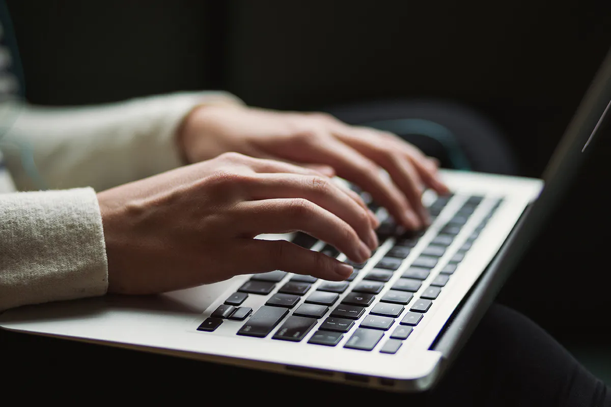 hands typing on laptop