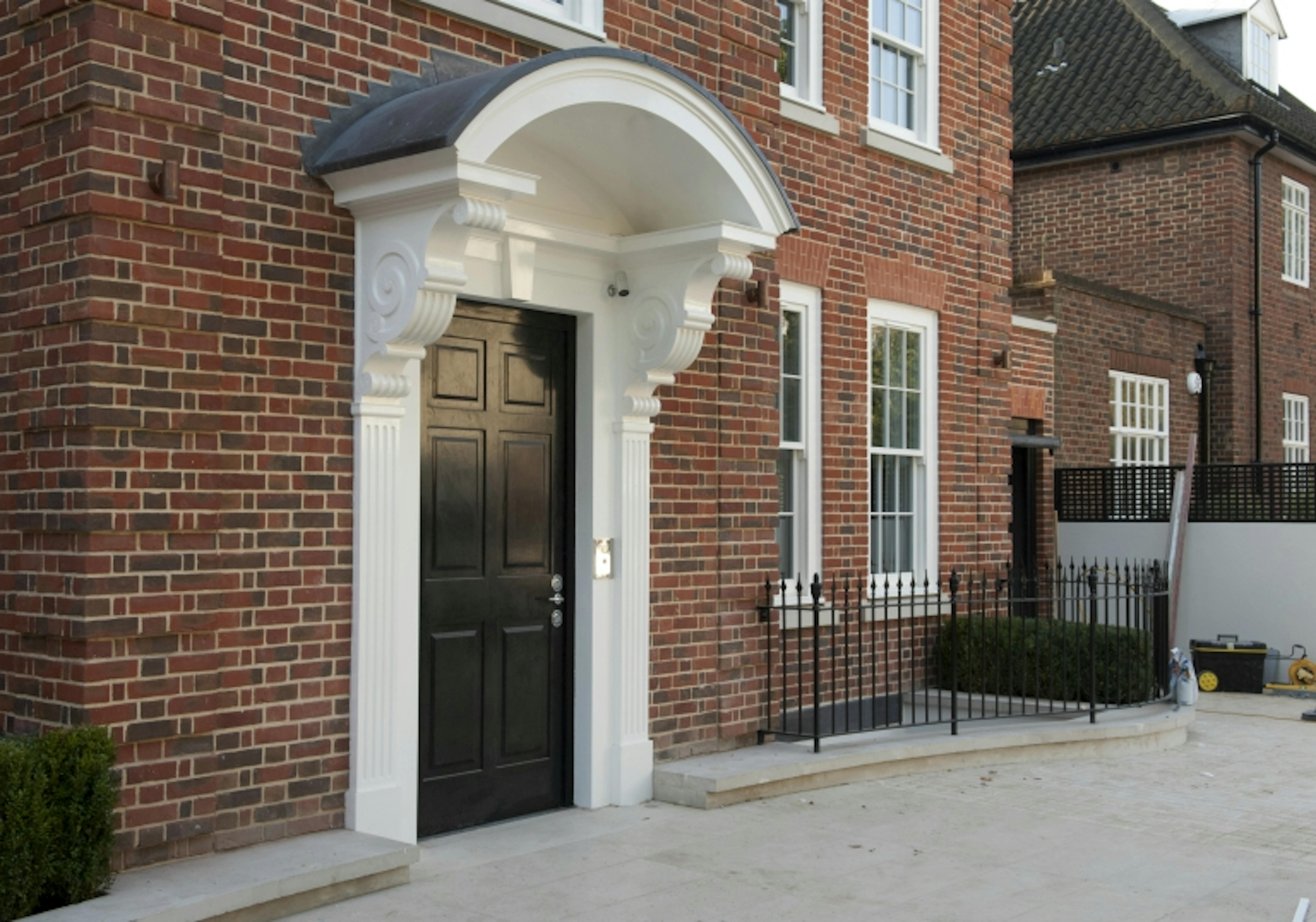 Red brick georgian style home featuring a classic 6 panel period style front door in a black painted finish by Deuren.