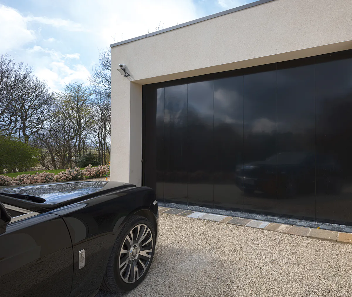 A car waiting in front of a black garage door