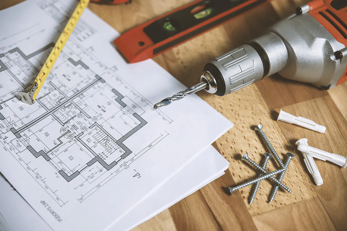 workbench top covered with technical drawings and tools.