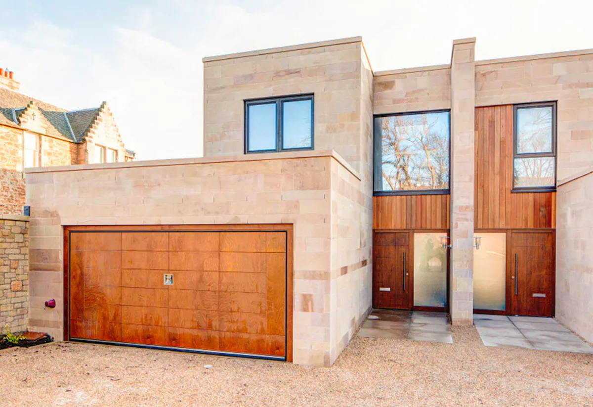 A modern house with a large wooden garage door.