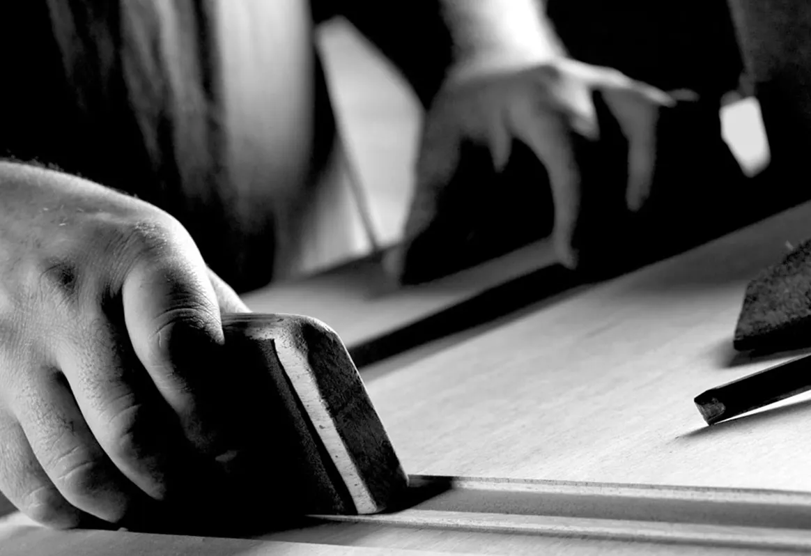 Close up of a hand sanding a door