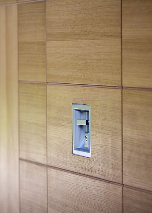 Close-up of a wooden panel with a rectangular fingerprint scanner built into it.