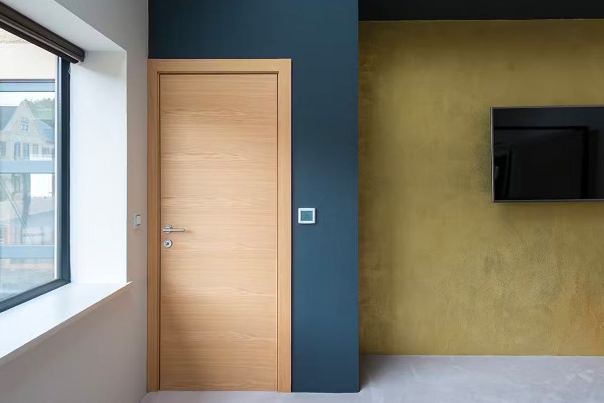 A light and airy bedroom featuring a contmporary internal door set by Deuren - Trem H, natural oak.