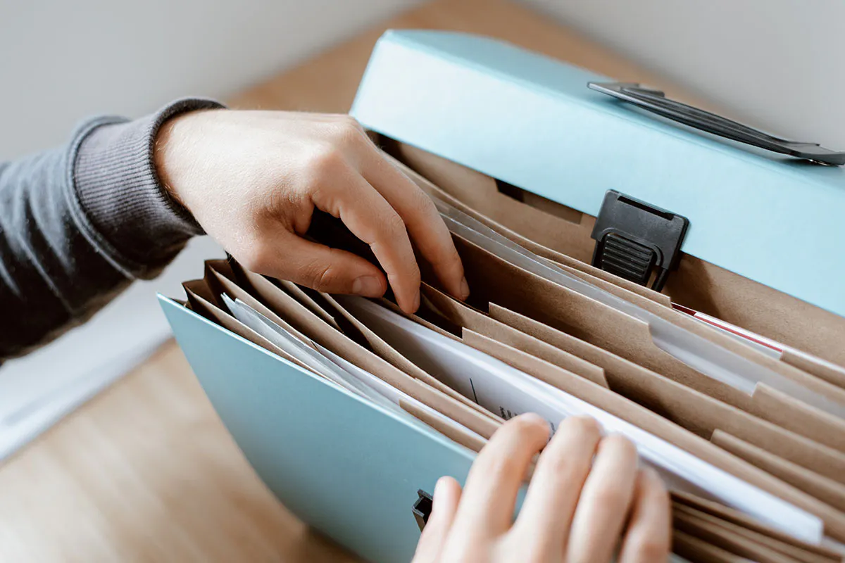 hands looking through a file organiser