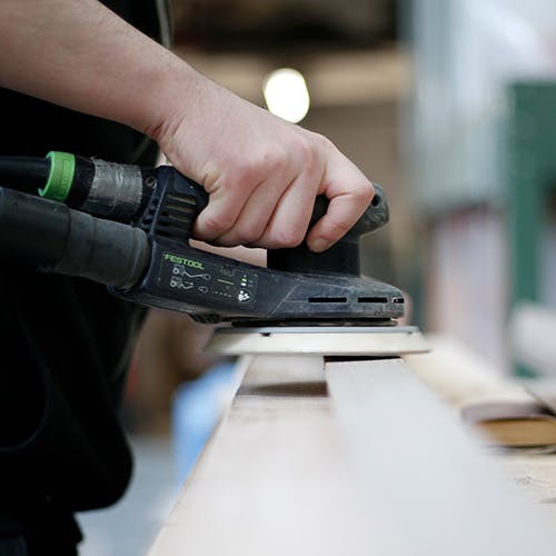 Close up of a hand sanding a Deuren door