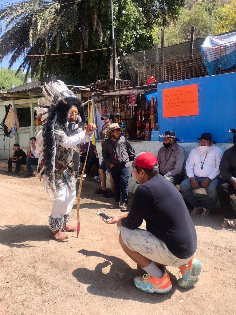 Periodista toma fotos de un indigena con vestuario tradicional
