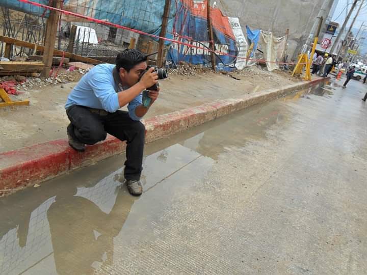 Periodista usa su camara para tomas una fotografia