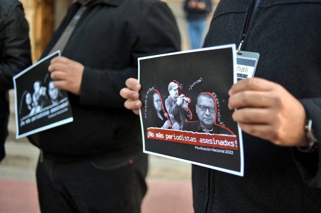 periodistas con hojas en la mano protestan por el asesinato de periodistas