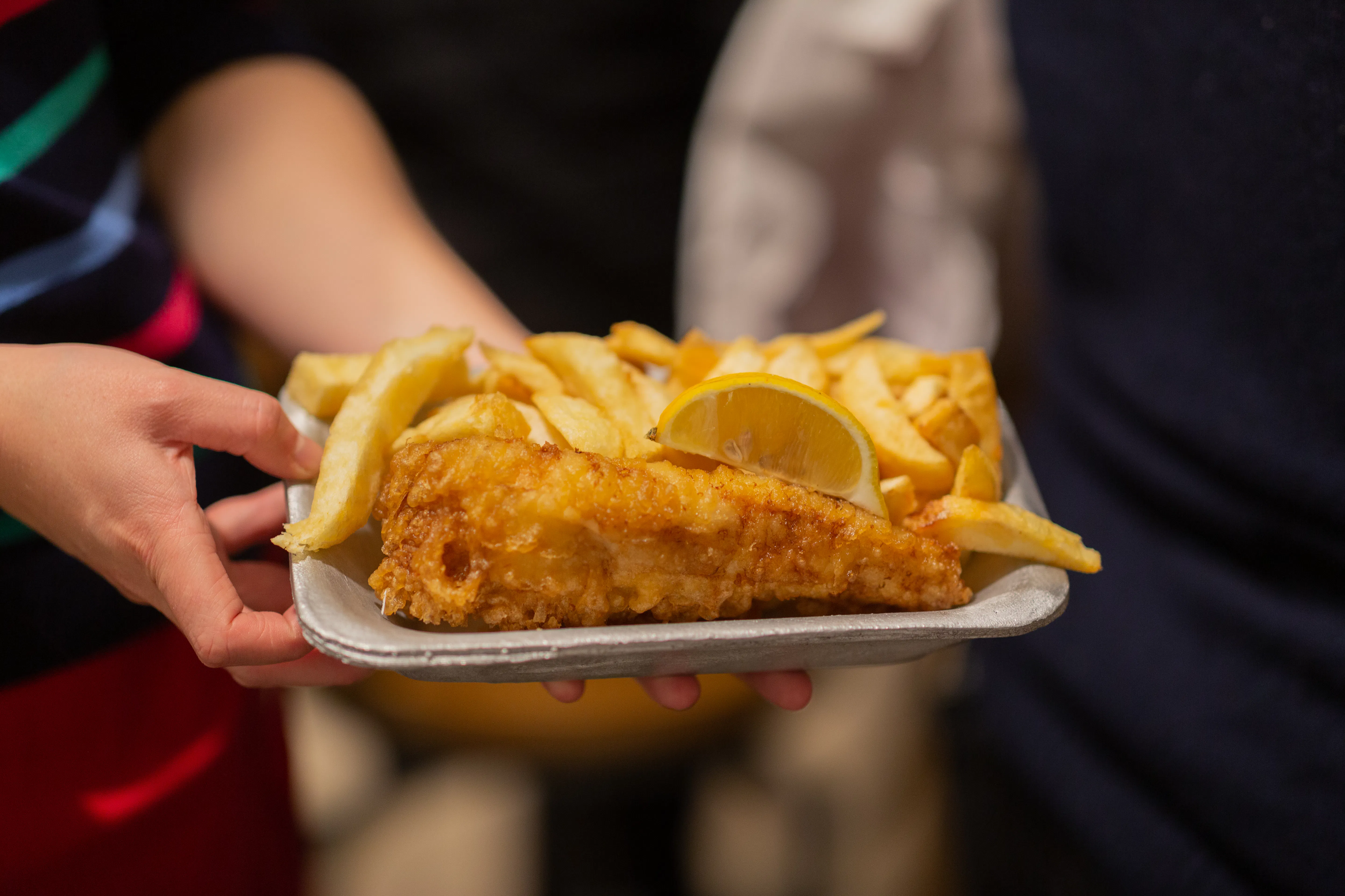 A photo of a fish supper on a cast aluminium tray.