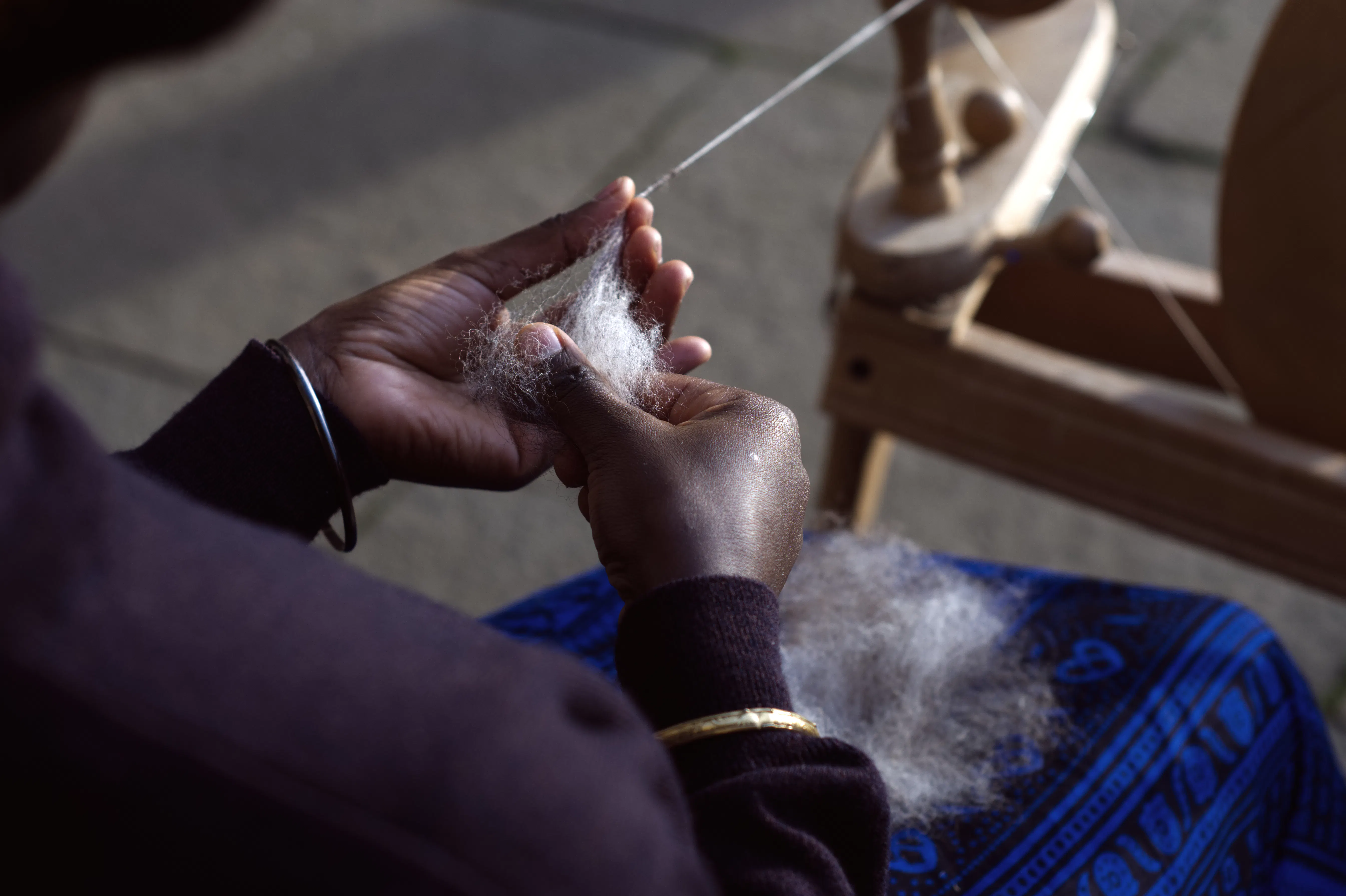 A photo of a person spinning wool. 