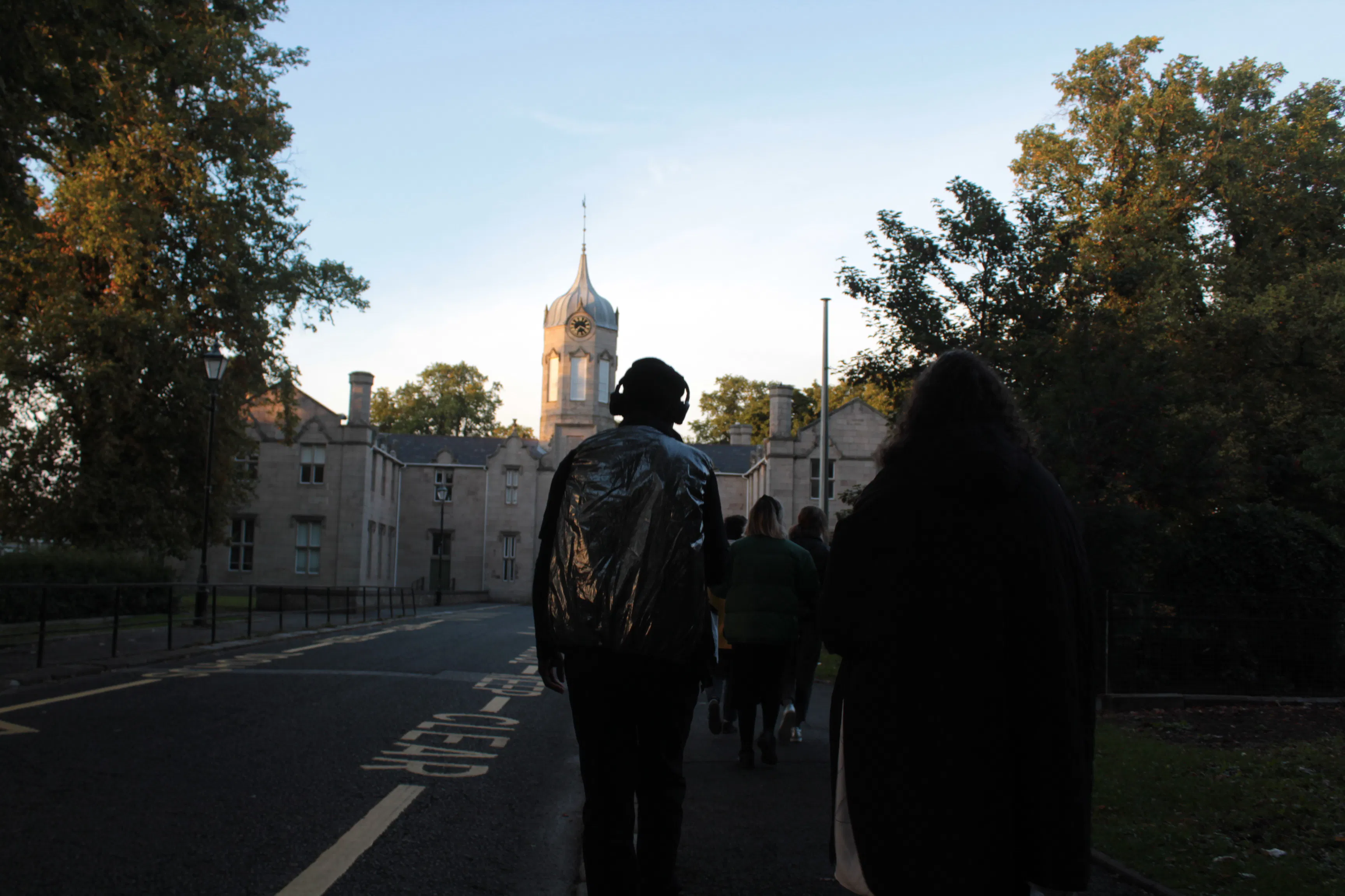 A photo of a person walking wearing headphones.