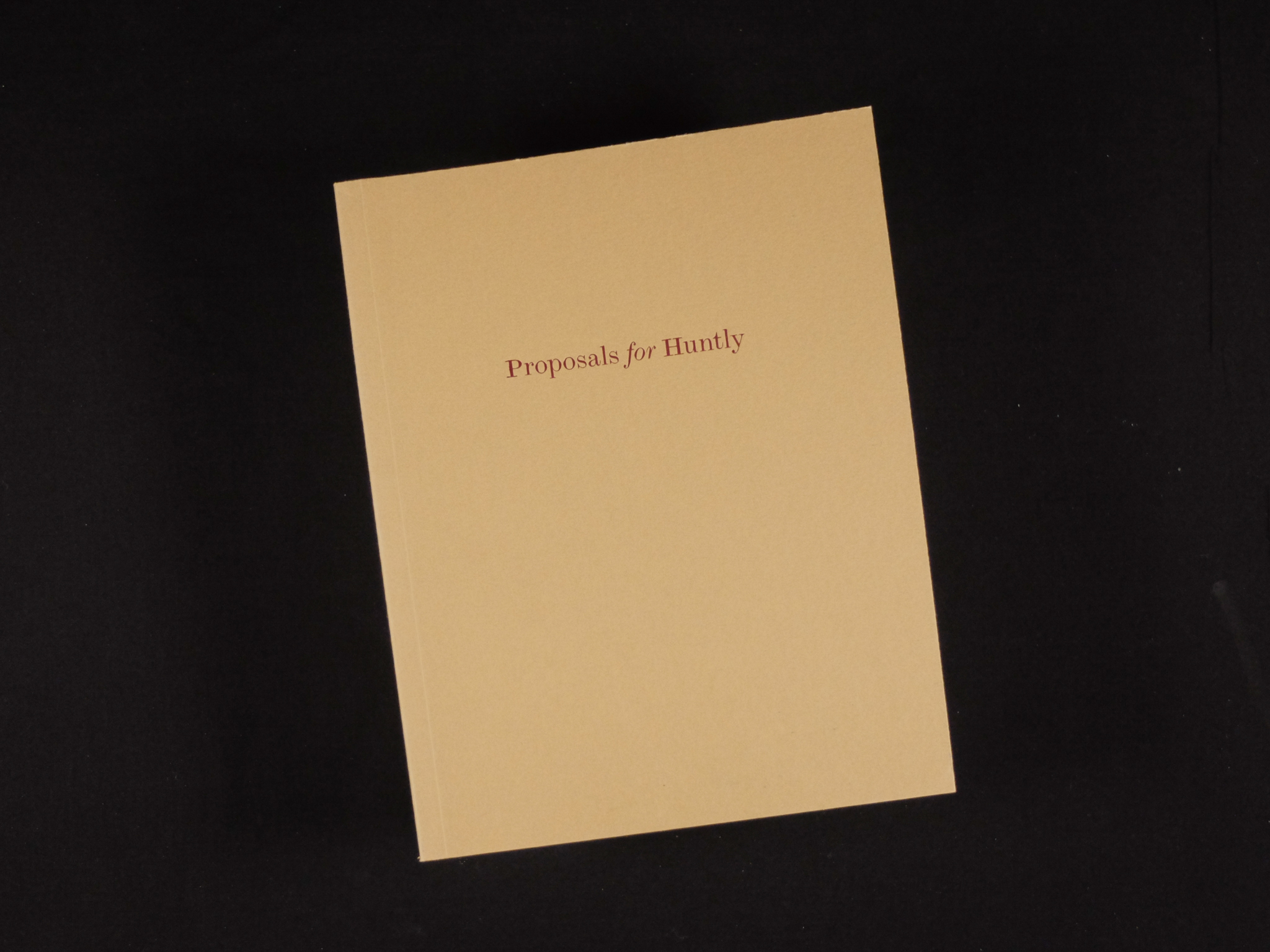 The brown cover of a book on a black background. In red text, 'Proposals for Huntly' is written in the top half of the book cover.