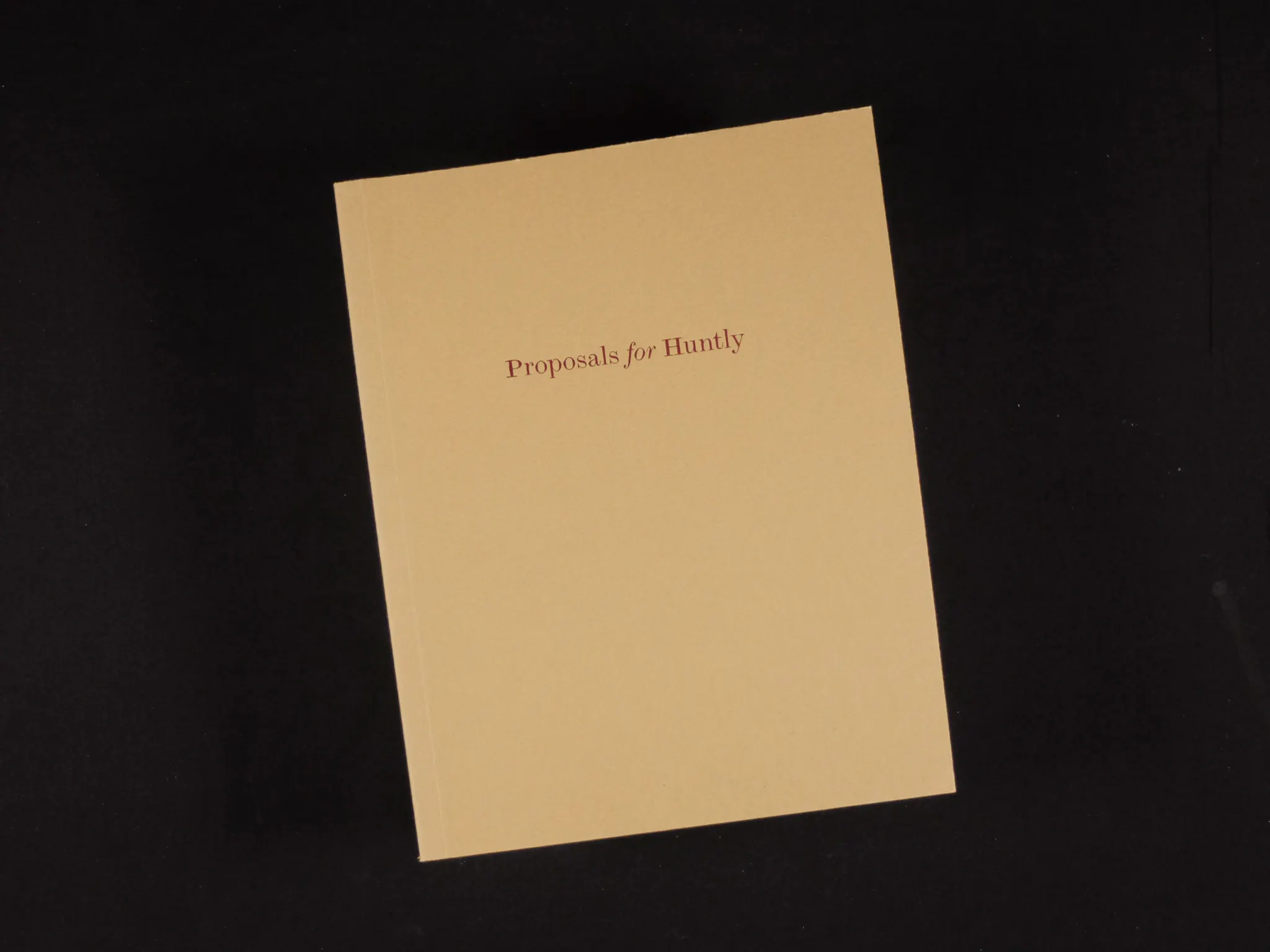 The brown cover of a book on a black background. In red text, 'Proposals for Huntly' is written in the top half of the book cover.