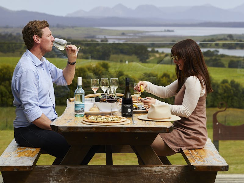 Couple enjoying food and wine on deck at Devil's Corner Cellar Door