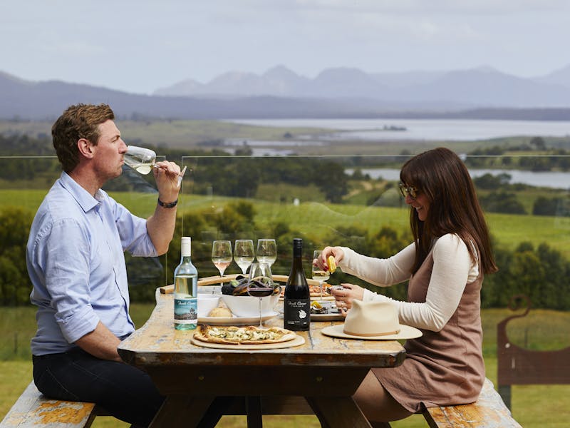 Couple enjoying food and wine on deck at Devil's Corner Cellar Door