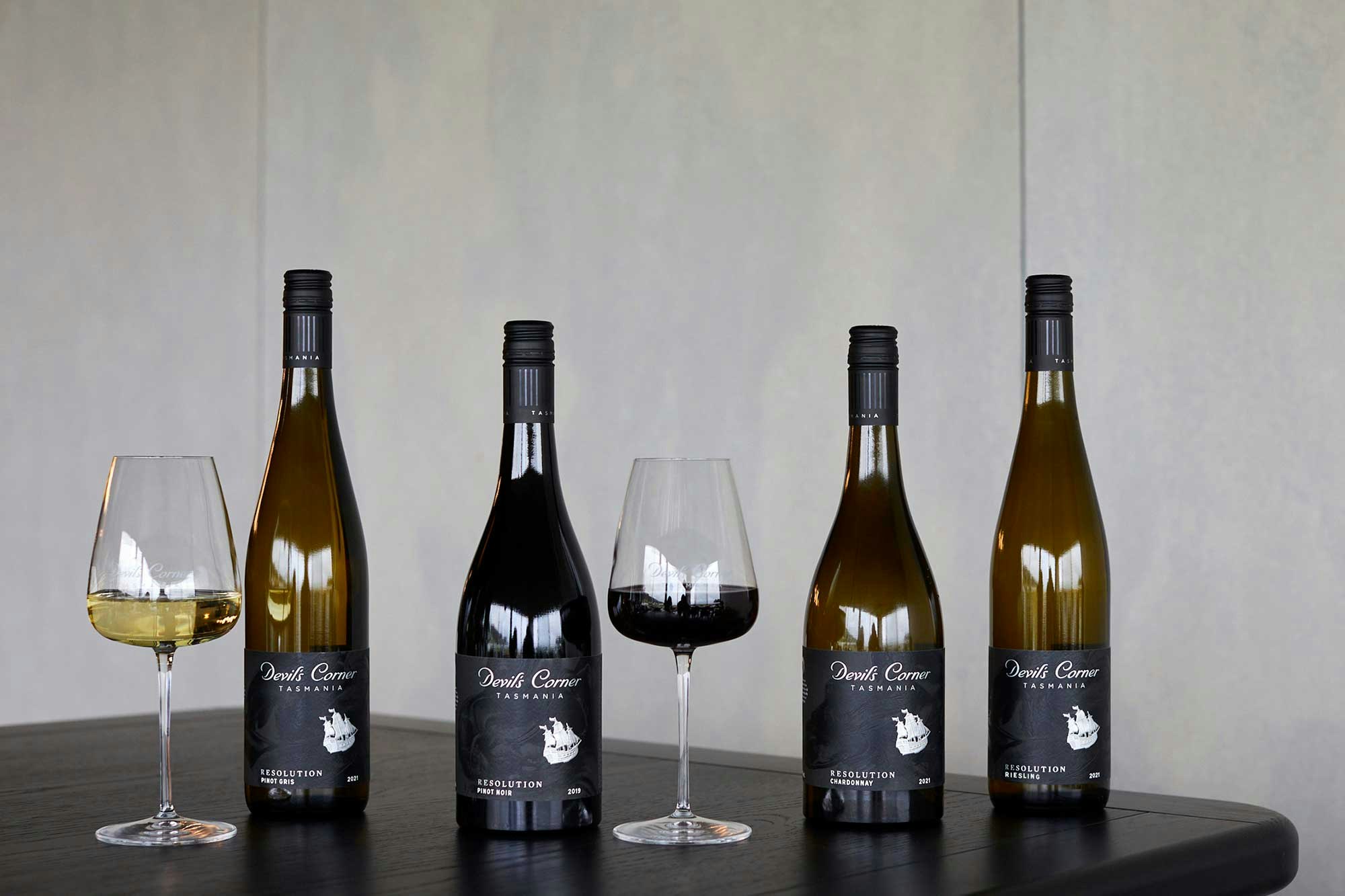 4 bottles of Devil's Corner Resolution alongside two glasses on wine on a table